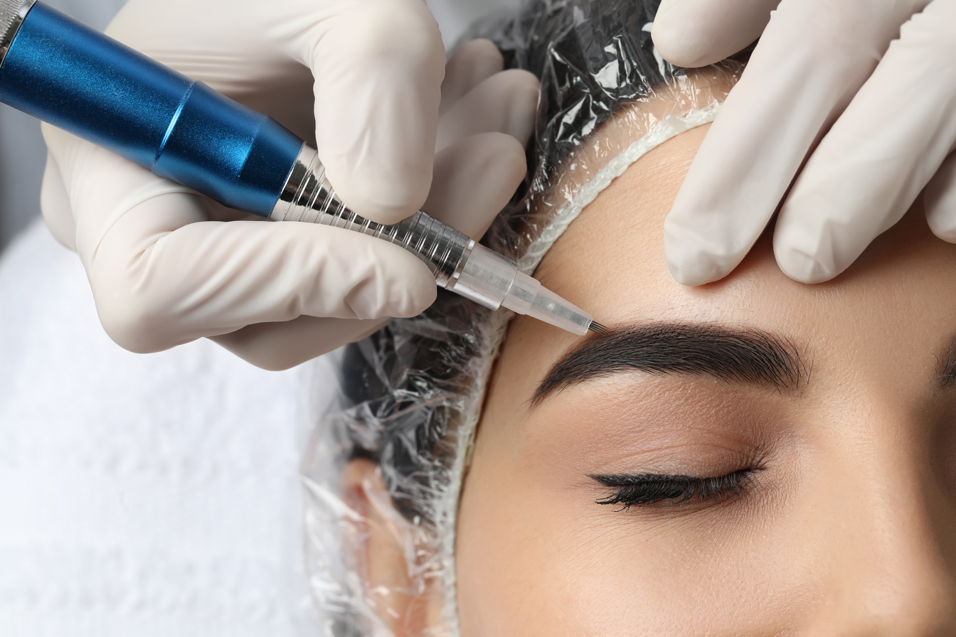 Young Woman Undergoing Procedure of Permanent Eyebrow Makeup in Salon, Closeup