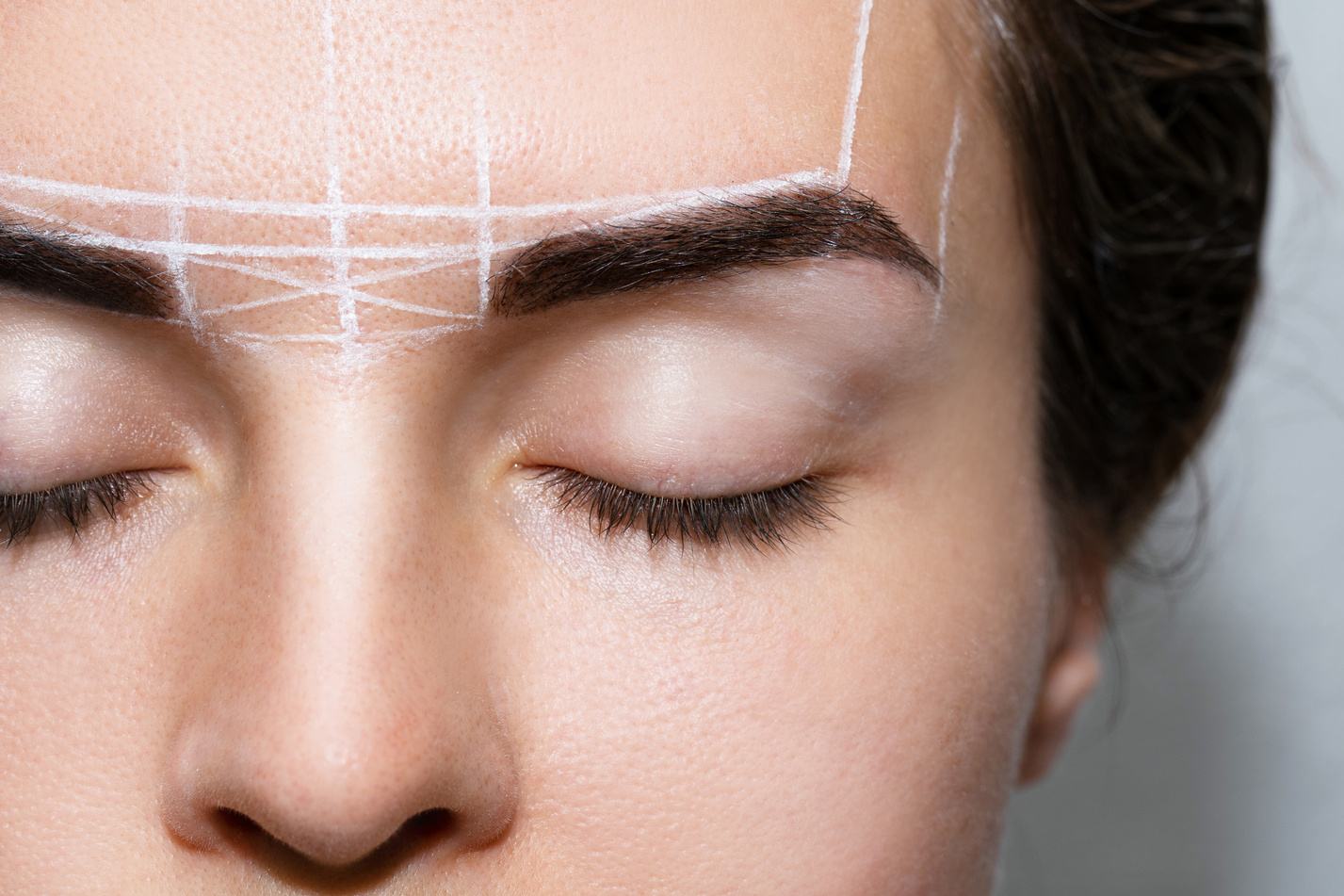 Woman during Professional Eyebrow Mapping Procedure